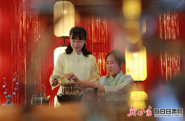 金塔汽车维修中等专业学校“金色胡杨梦工厂”的茶道茶艺坊，指导教师高颖洁（左一）正在配合学生杨婷冲泡当地人喜爱的“罐罐茶”.jpg